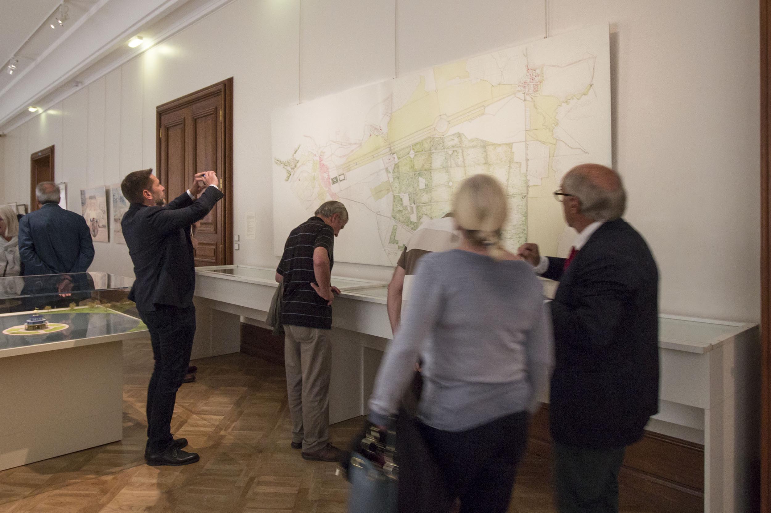 Lors du vernissage de l'exposition, le public regarde le panneau très grand format avec l'ancien plan du parc du château de Saverne