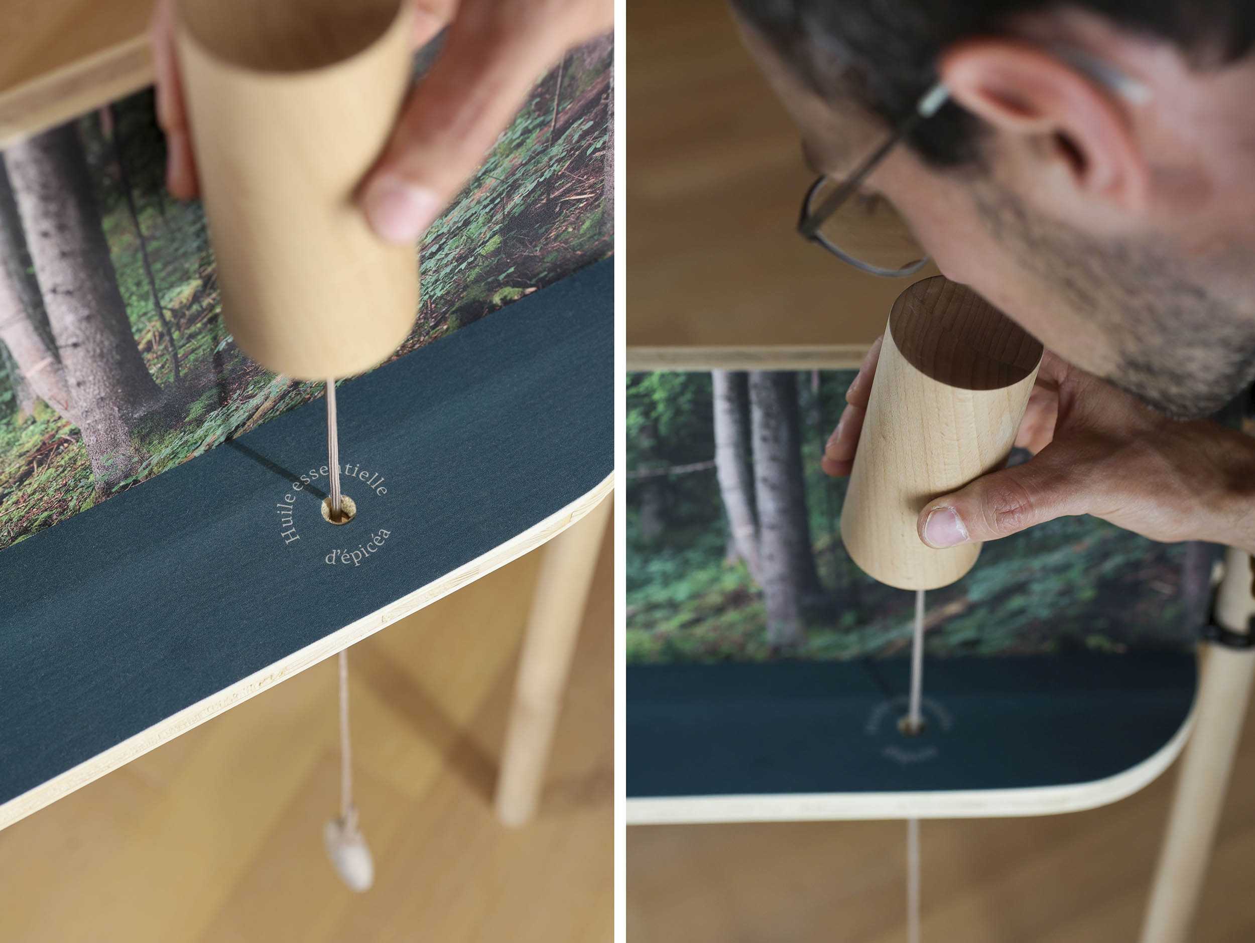 Une pièce de bois est tenue en main et sentie par le visiteur. On lit, sur le support "Huile essentielle d'épicéa".