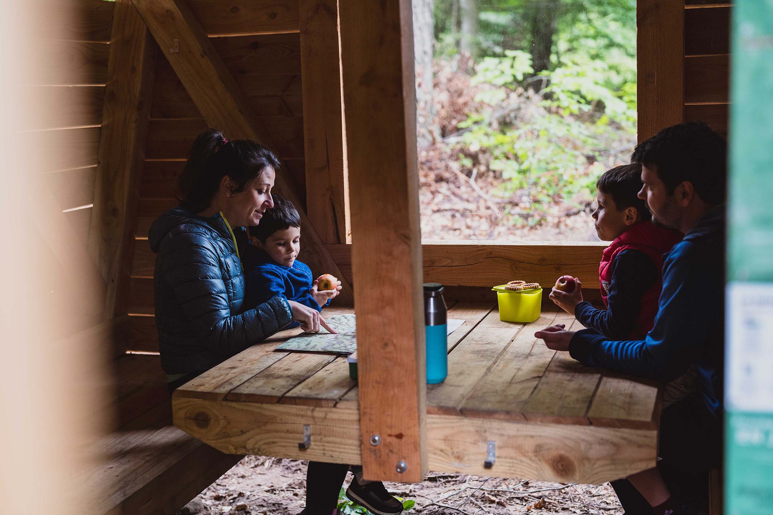 Les randonneurs sont attablés en famille autour de la table de l'abri